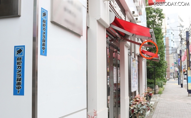 パチスロ店の店頭に設置された防犯カメラ。防犯カメラ設置のステッカーなどもあり防犯効果を発揮（撮影：防犯システム取材班）